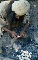 Ika man burning sea shells  brought into the Sierra from the Caribbean Coast  to make very fine powdered lime which is carried in a poporo small gourd  then inserted into a wad of coca leaves constant...