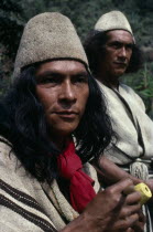 Head and shoulders portrait of two Ika men in traditional dress.Helmets made from fique cactus fibre and mantas cloaks from woven wool&cotton. Both members of the powerful Villafana familyArhuaco Aru...