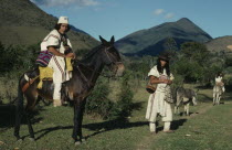 Ika leader Vicente Villafana on mule outside the Ika administrative centre of Nabusimake  another man at his side  both men in traditional dress of woven wool&cotton mantas cloaks  mochilas shoulder b...