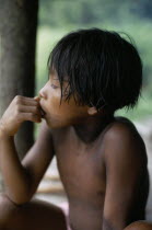 Portrait of Embera boy with typical fringe haircut sitting at entrance to stilted family home. Faint body decoration marks from purple/black dye extracted from Jagua fruit  still visible ten days afte...