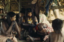 Embera family group with young women painted with black dye extracted from Jagua fruit and wearing brightly coloured glass bead necklaces.Tiny glass beads  originating from Europe are coveted trade go...