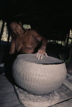 Embera woman puts final touches to a large clay cooking pot. Fashioning the poit with her fingers she smoothens the surface with a smooth river-worn pebble  Skill is only continued by a few elderly wo...