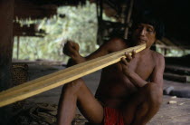 Embera family head  Heraklio  finely shaping wooden canoe paddle at riverside home on rio Baudo Pacific coastal region boat oar tribe American Colombian Colombia Hispanic Indegent Latin America Latin...