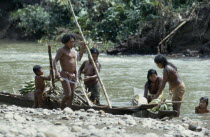 Embera family arrive back at riverside home by dug-out canoe with sugar cane maize and bananas from their forest cultivation plot Pacific coastal region boat piragua tribe