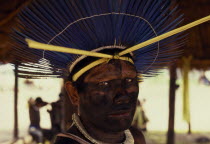 Portrait of Panara male elder wearing ceremonial crown made from blue parrot feathers  face painted black from eyes to neck.Relocated in Xingu National Park by Villas Boas brothersFormally known as K...