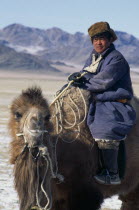 Mongolian nomad returning to camp on camel.