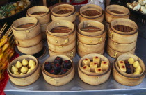 China, Beijing, Donghua Yeshi food market,  display of bamboo steamers of sweetmeats.