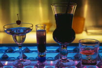 Tou Ming Si Kao  TMSK  bar.  Cocktails on glass bar illuminated blue and purple.