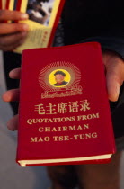 Tiananmen Square.  Person holding copy of Mao Tse-Tung s  Little Red Book  of quotations  required reading of all Chinese citizens during Mao s rule.