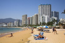 Condominiums and hotels beside beach  people sunbathing.