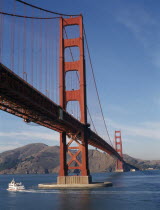 The Golden Gate Bridge with a ferry traveling past on the water below