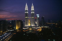 Petronas Towers and city skyline illuminated at sunset