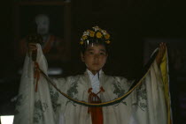 Portrait of young shrine maiden employed to welcome visitors  supervise offerings and perform sacred dances for the Shinto gods or kami.
