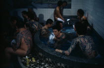 Heavily tattooed gangster or Yakuza gang members in public bath house.