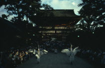 Gion District  Yasaka Shrine.  Performance of the Dance of the White Herons in outside courtyard watched by large crowd.  Believed to have originated in the ninth century as a feature of Shinto ritual...