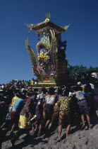 Crowd carrying body of deceased to burning ground in highly decorated cremation tower where it will be transferred to a wooden bull which transports the soul to Paradise and everything will be burnt....