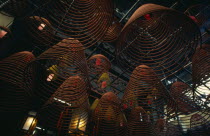 Spiral cones of incense hanging from roof of the Man Mo or warlord temple.  The warlord god is Kwan Tai and is patron of both police and gangsters.  A historical figure from the Three Kingdoms period...