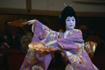 Use of traditional Geisha dances in modern choreography.  Female dancer with fans in afternoon show in the Kabuki Theatre.