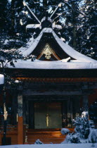 Mount Koyosan.  Shinto shrine in thick layer of snow over roof  ground and surrounding trees.  Shinto worship entails a belief in ancestor and nature spirits.