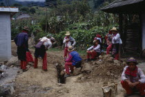 Group of men wearing traditional dress looking at recently dug drainage channel  maize  squash and fruit trees behind.