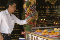 Chinese New Year celebrations. A worshiper lighting joss sticks at a Chinese temple  Warorot Market  Chiang Mais China Town