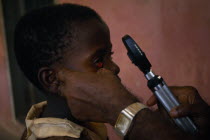 Child having eye examination by Doctor using a ophthalmoscope.