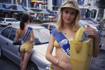 Meter maids dressed in gold lame bikini swimwear. The girls carry coins to feed parking meters and are sponsered by local businesses. Came into being after the introduction of parking meters in 1965 w...