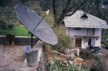 Satelite Dish in a bucket on the wall of  a remote country home.