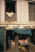 Durbar Square butchers with display of goods and people at a window above