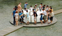 VIEW OF THE BASE OF THE FOUNTAIN OF WEALTH WITHIN THE SUNTEC CITY SHOPPING COMPLEX.The circular ring top of the fountain is visible at ground level. During certain periods of the day  the fountain is...