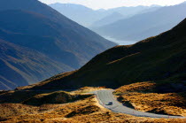 ARROWTOWN  THE CROWN RANGE ROAD FROM CARDRONA TO ARROWTOWN WITH THE MOUNTAIN RANGE KNOWN AS THE REMARKABLES AT QUEENSTOWN ON THE HORIZON.Antipodean Oceania Scenic