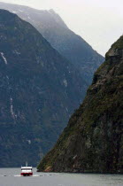 SOUTHLAND  A CRUISE BOAT TRAVELS ALONG MILFORD SOUND IN NEW ZEALANDS FJORDLAND AREA.Antipodean Oceania