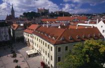 View over paved square and red tiled rooftops of the Old Town towards Cathedral of St Martin and Bratislava Castle.