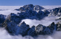 View over snowy peaks of the High Tatras mountains above drifting cloud from the Lomnicky Stit viewpoint.