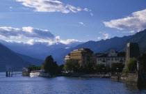 Pallanza.  Lakeside buildings  crowds and moored ferry boat with mountain backdrop.