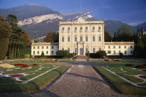 Private villa and formal gardens near Tremezzo  gravel drive leading to entrance steps and lawns inlaid with stone patterns.  Mountains behind.
