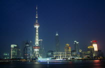Pudong at night with illuminated skyscrapers and buildings including the Oriental Pearl Tower and Jin Mao Building.