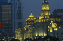 The Bund at night with skyscrapers and the Customs House illuminated.