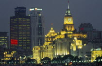 The Bund at night with skyscrapers and the Customs House illuminated.