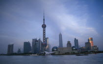 Pudong skyline at dusk with skyscrapers including the Oriental Pearl Tower and the Jin Mao Building.