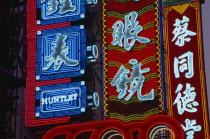 Nanjing Lu.  Illuminated neon shop signs in Chinese script.