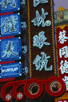 Nanjing Lu.  Illuminated neon shop signs in Chinese script.