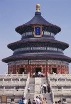 Tiantan Park.  The Hall of prayer for Good Harvests   qi nian dian  .  Tiered  highly decorated exterior with visitors on steps in foreground.