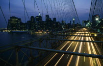 Brooklyn Bridge with speeding traffic headlights at night