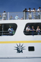 Circle Line ferry to Liberty Island with passengers leaning over the sides