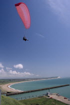 Tandem paraglider above Fort Newhaven with the Mole  Lighthouse  Seaford bay and Seaford in the background.