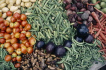 Close cropped view of vegetables displayed on market stall including okra  aubergines  tomatoes  beetroot  potatoes and carrots.