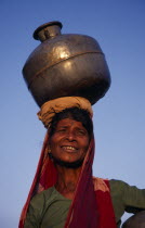 Woman carrying water pot on her head.