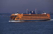 Staten Island ferry with city skyline beyond.