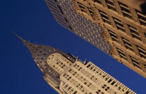 Angled view of the Chrysler Building from Lexington Avenue beside ornamented tower block exterior.  Steel framed Art Deco skyscraper built 1928-1930.Designed by architect William Van Alen.